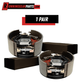 A pair of RGP 12,000lb Axles electric trailer brake assemblies with curved gray metal shoes and exposed springs, magnets, and hardware.
